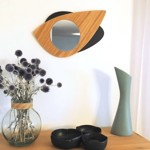 Miroir en bois DikromA. Modèle Cyclope en forme d'œil. Couleur bois naturel et teinté noir. Vue d'ensemble